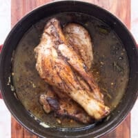 the lamb shanks and liquid are added to a slow cooker to slow cook