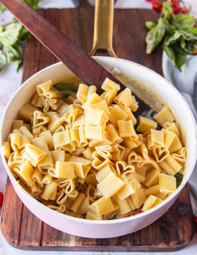drained and cooked pasta added to the sun dried tomato sauce in the pan