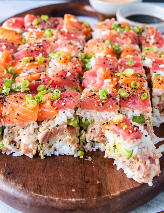 close up of sushi cake with one slice separated from the cake to show the serving process 