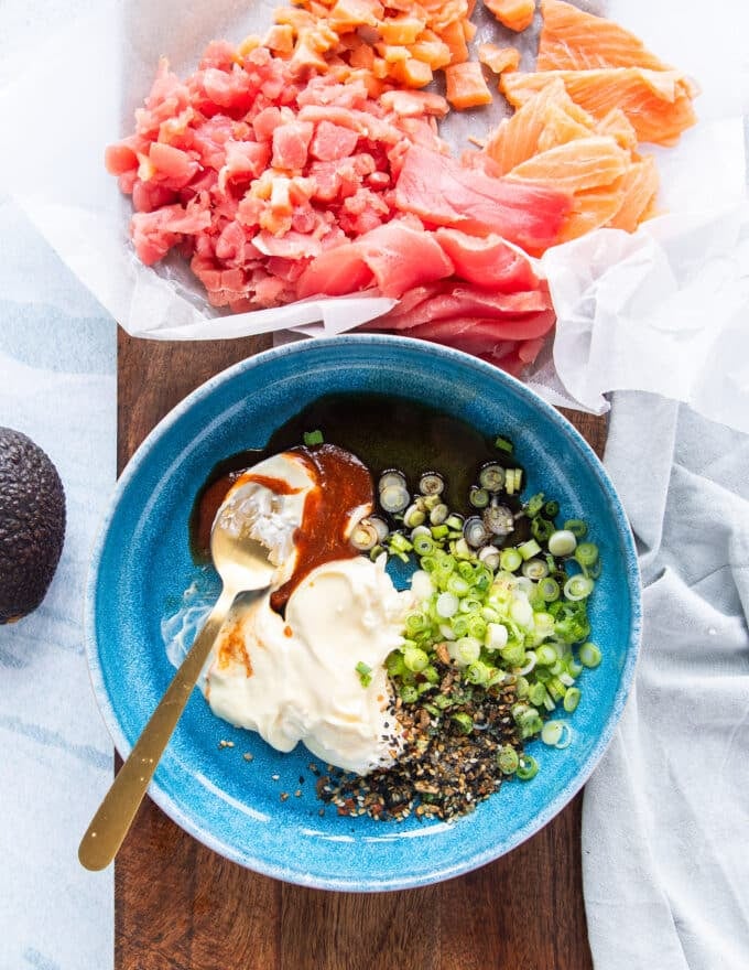 The aromatics for the filling like spicy mayo or kewpie, sriracha, soy sauce, green onions and more, are all added to a shallow bowl 