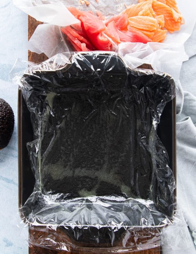 a square cake pan lined with plastic wrap to use for the sushi cake 