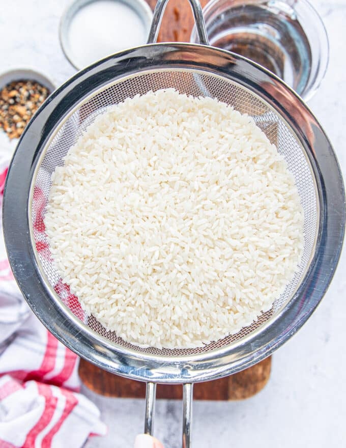 the short grain rice in a sieve ready to be rinsed and soaked