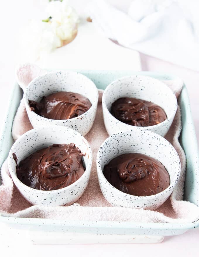 The brownie pudding batter is divided among the dishe 