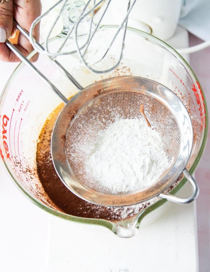 flour now being sifted into the brownie pudding batter 