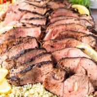 sliced butterflied leg of lamb arranged on a plate