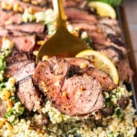 close up of a serving of butterflied leg of lamb on a slotted spoon showing the texture close up