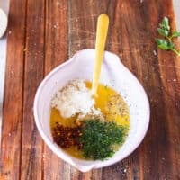 garlic butter herbs seasoning and lemon in a small bowl ready to mix for the garlic butter finish on the chicken spiedini