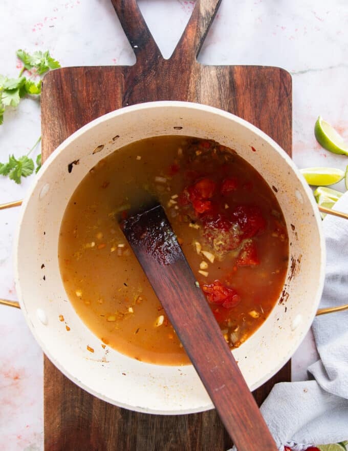 tomatoes and stock are added to the pot
