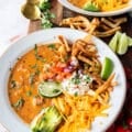 one bowl of perfect chicken taco soup close up topped with tortillas, avocado, sour cream, cilantro and cheese