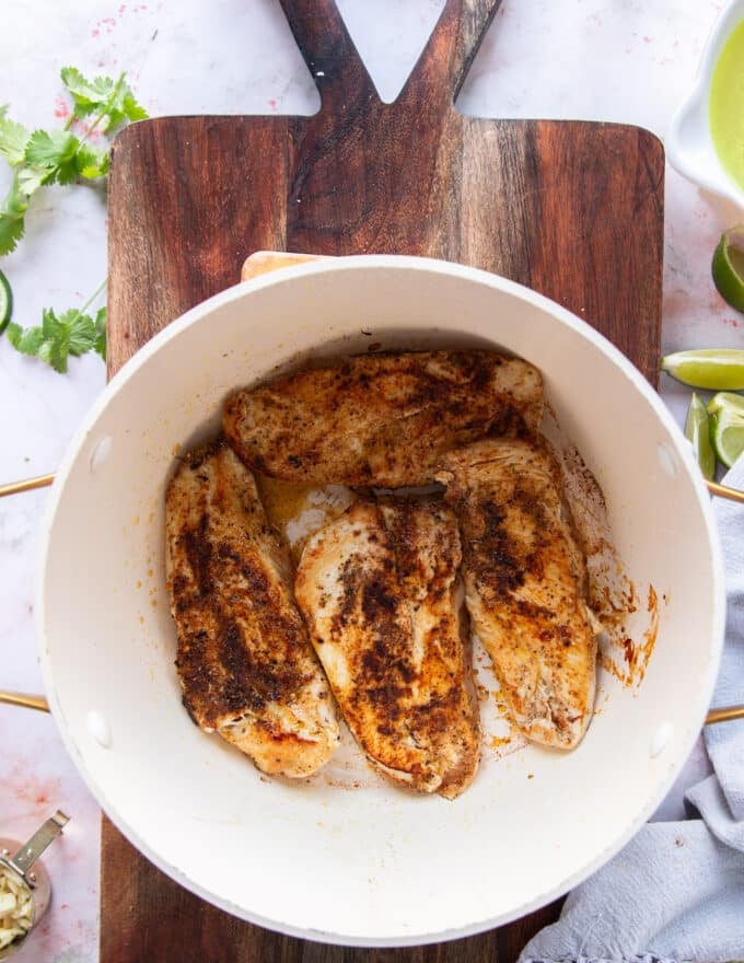 the seasoned chicken searing in a pot 