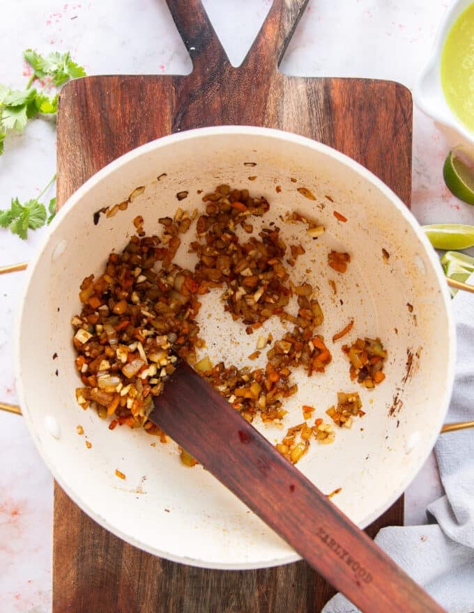 Onions, bell peppers and taco seasoning cooking to make the base of the chicken taco soup