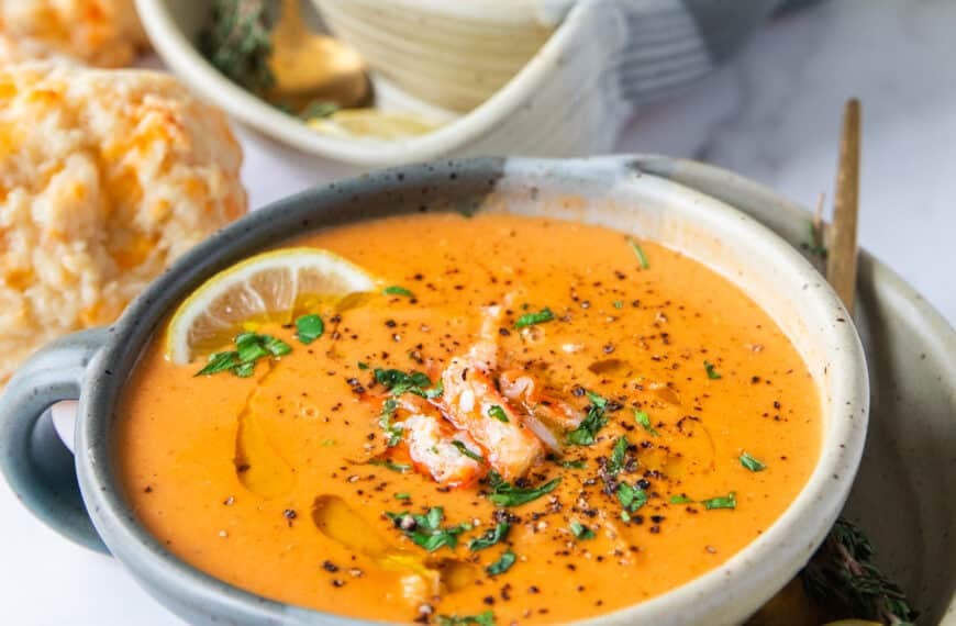 close up bowl of crab bisque with crab lumps on top and parsley