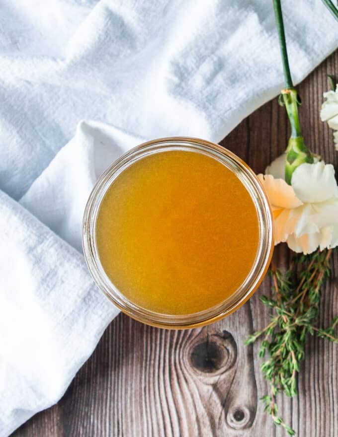 Top view of crab stock in a jar showing how clear and rich it is