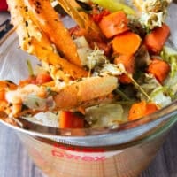crab stock being strained over a mesh strainer showing the clear seafood broth underneath