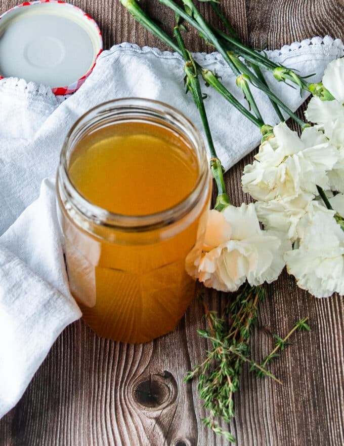 A large mason jar of crab stock, clear and rich in color and taste