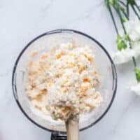 Cold buttermilk or milk and shredded cheese is added to the food processor bowl
