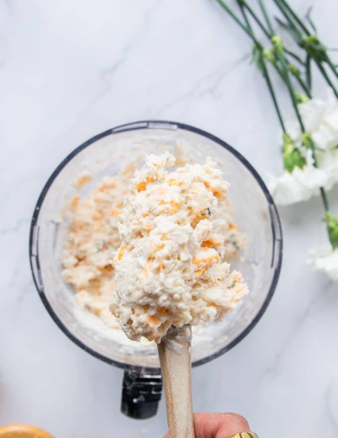 Cold buttermilk or milk and shredded cheese is added to the food processor bowl