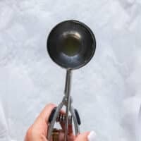 An ice cream scoop is used to scoop the dough