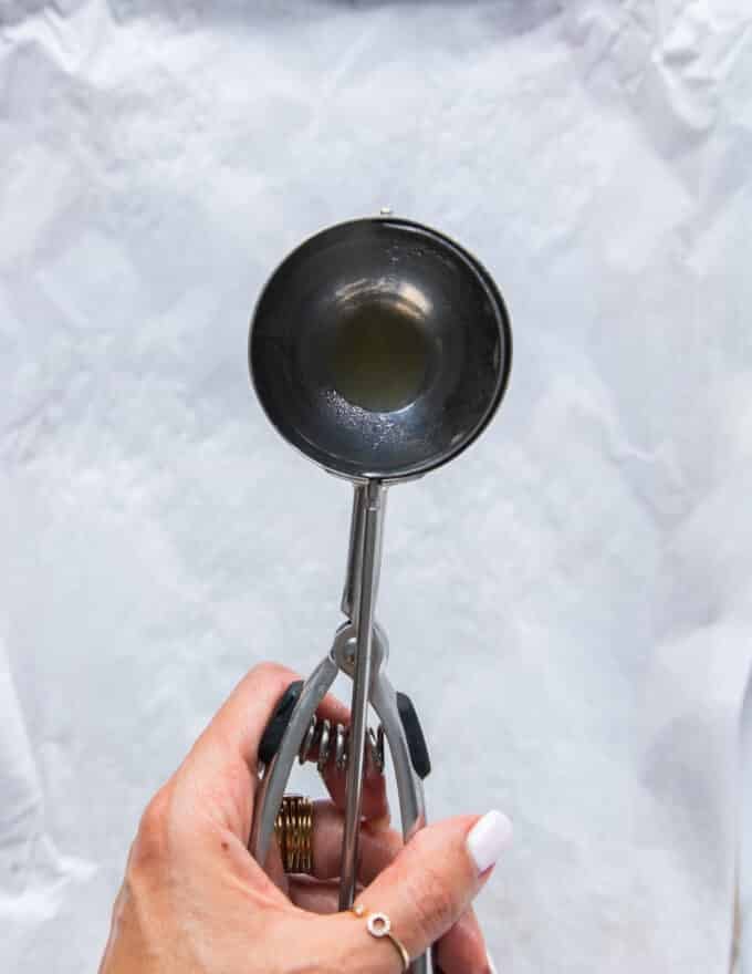 An ice cream scoop is used to scoop the dough 