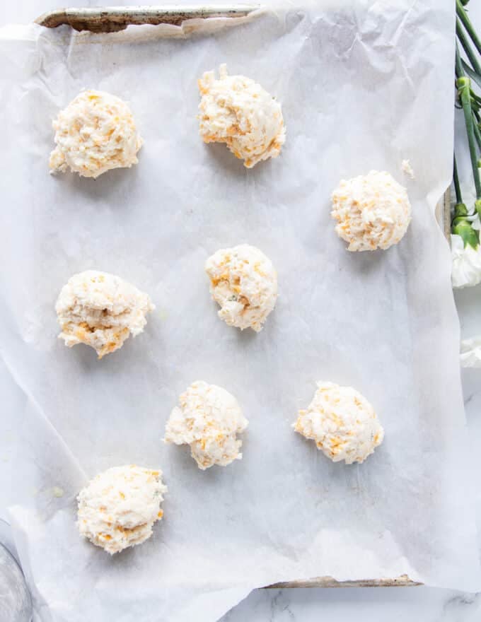 drop biscuits dropped on a baking sheet lined with parchment paper ready to go into the oven