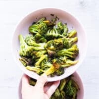 close up plate of perfect frozen broccoli in air fryer with golden crisp edges and green tender insides