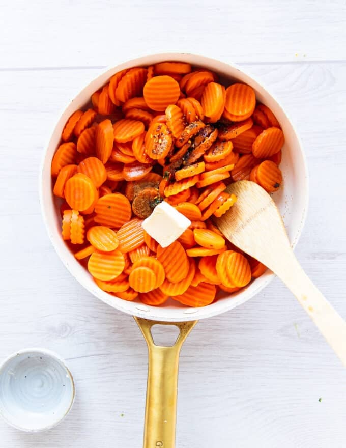 seasoning, maple syrup and butter are added to the partially cooked carrots