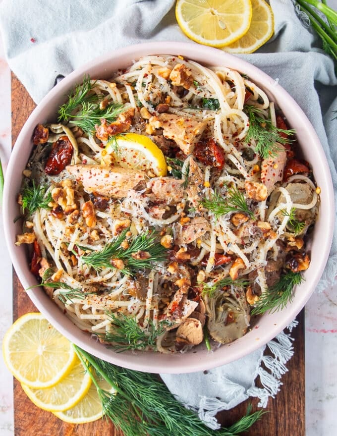 top view of a bowl of tuna pasta with fresh dill and lemon slices