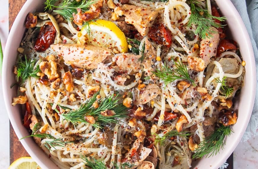 top view of a bowl of tuna pasta with fresh dill and lemon slices