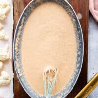 water is added and the batter is ready in a shallow bowl to make buffalo cauliflower bites