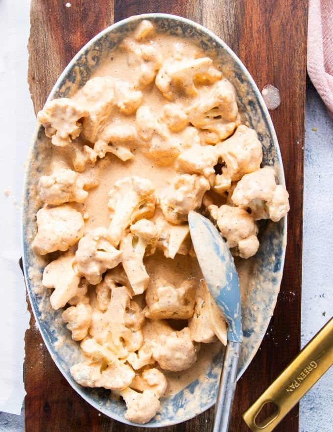 the cauliflower is tossed in the batter and coated evenly with the thick batter