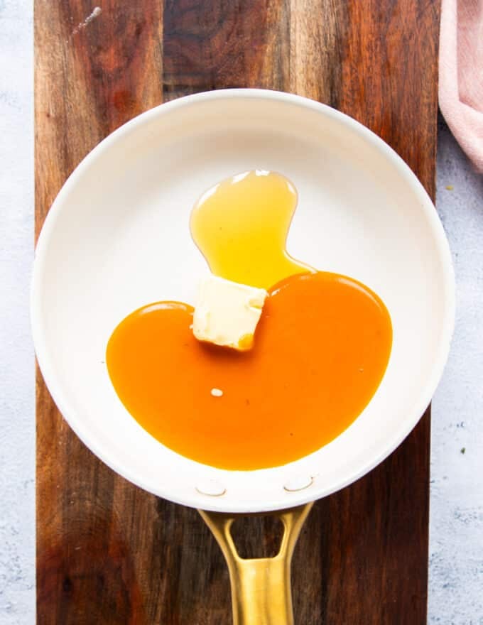 buffalo sauce, honey and butter in a skillet melting to form the buffalo coating 