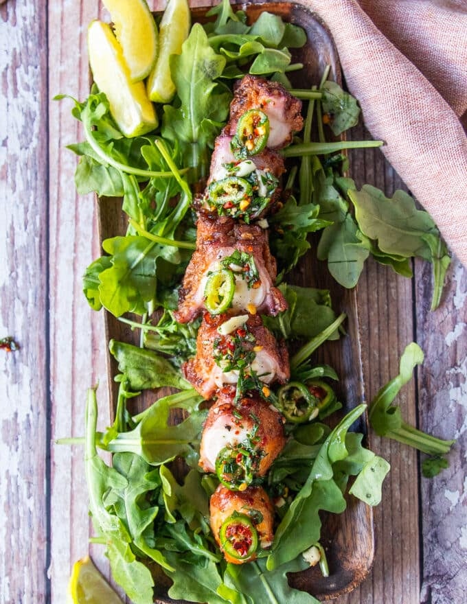 a plate of crispy fried octopus with lime and lemon wedges