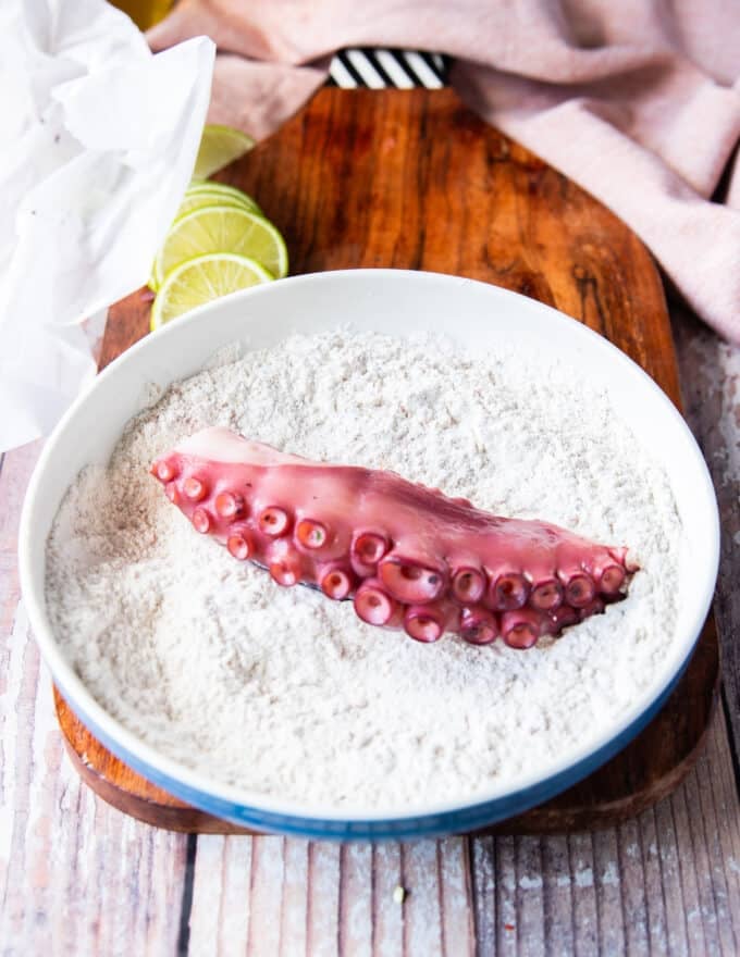 octopus added to a seasoned flour bowl