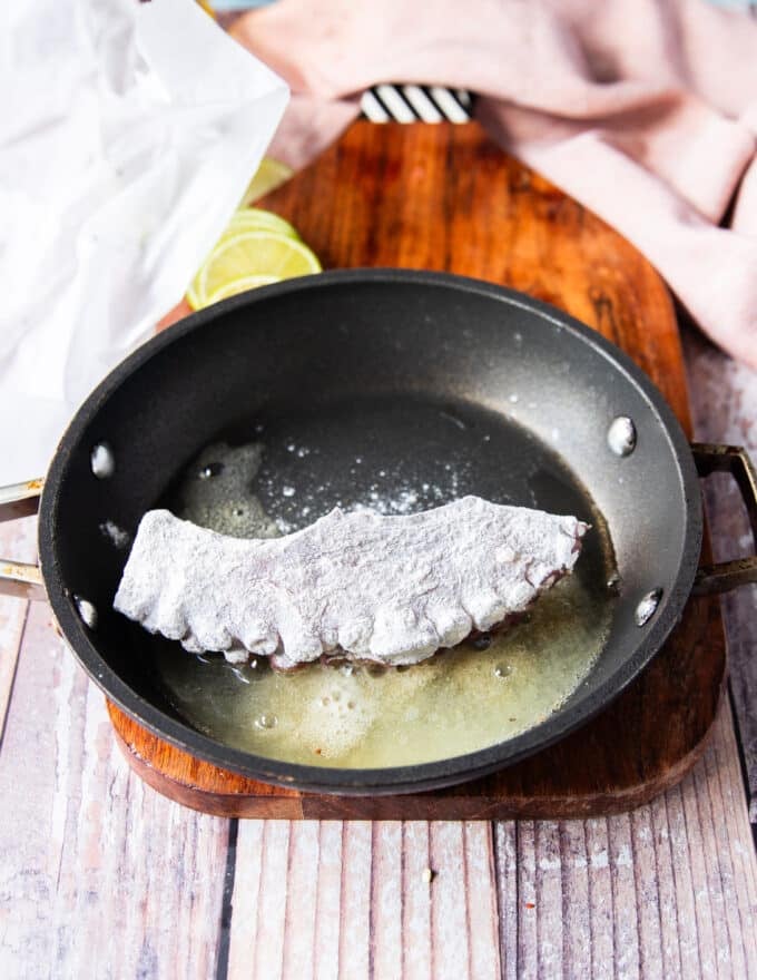 The flour coated octopus added to the frying pan
