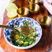 a bowl with mixed olive oil, lemon juice, garlic, herbs, chili flakes and seasoning to drizzle over the fried octopus