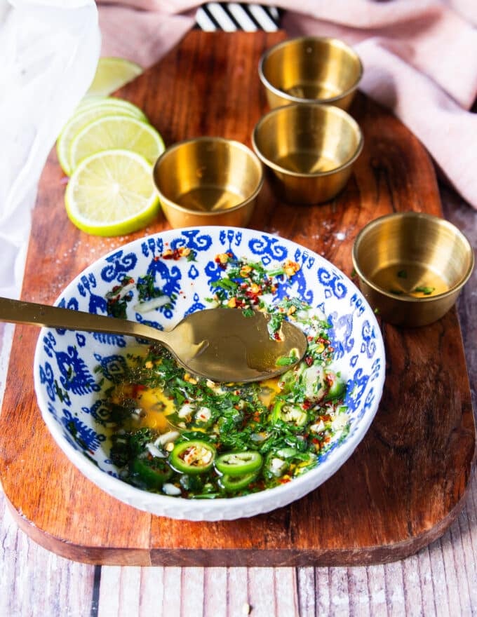 a bowl with mixed olive oil, lemon juice, garlic, herbs, chili flakes and seasoning to drizzle over the fried octopus
