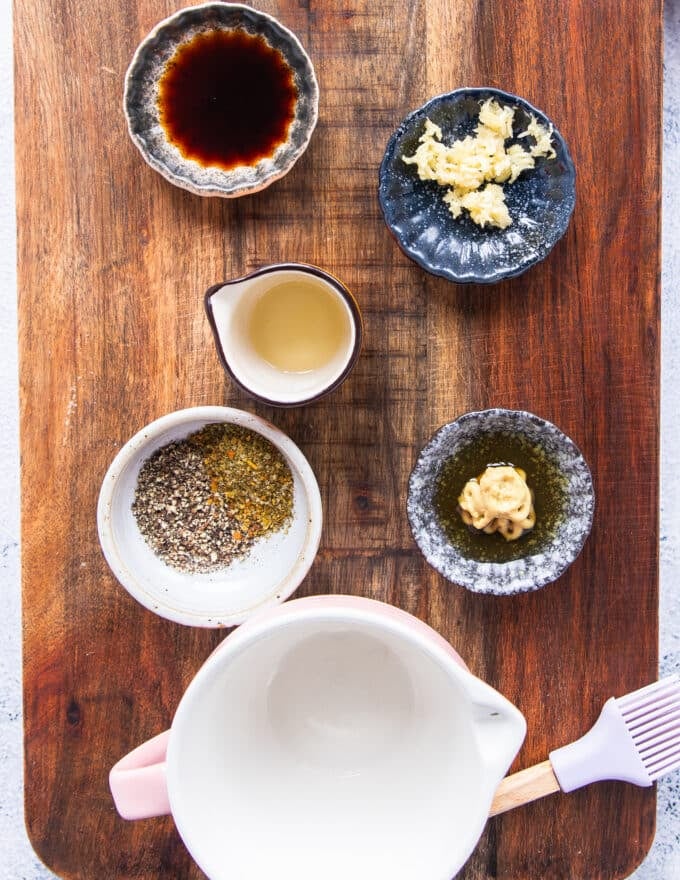 small bowls of marinade for the kingfish steaks including minced garlic, mustard, honey ,soy sauce, herbs, olive oil and more 