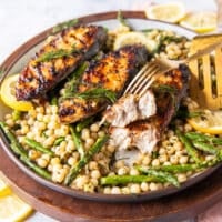 fork breaking apart a king mackerel steak showing the texture on the side and crispy skin