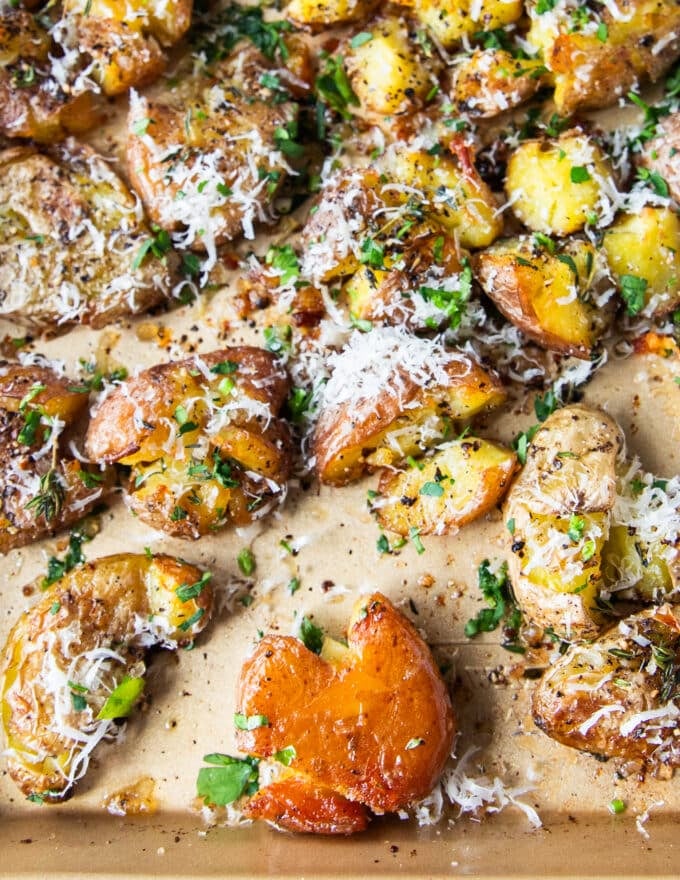 close up of a flipped up smashed potatoes on a tray of smashed potatoes showing how golden and crisp it is