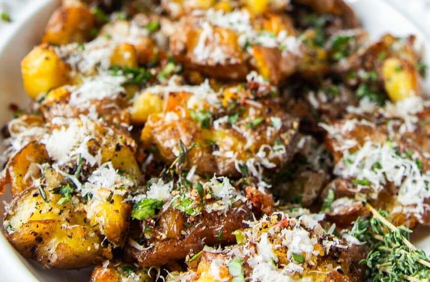 smashed potatoes on a serving plate close up showing the fluffy inside and crisp outside