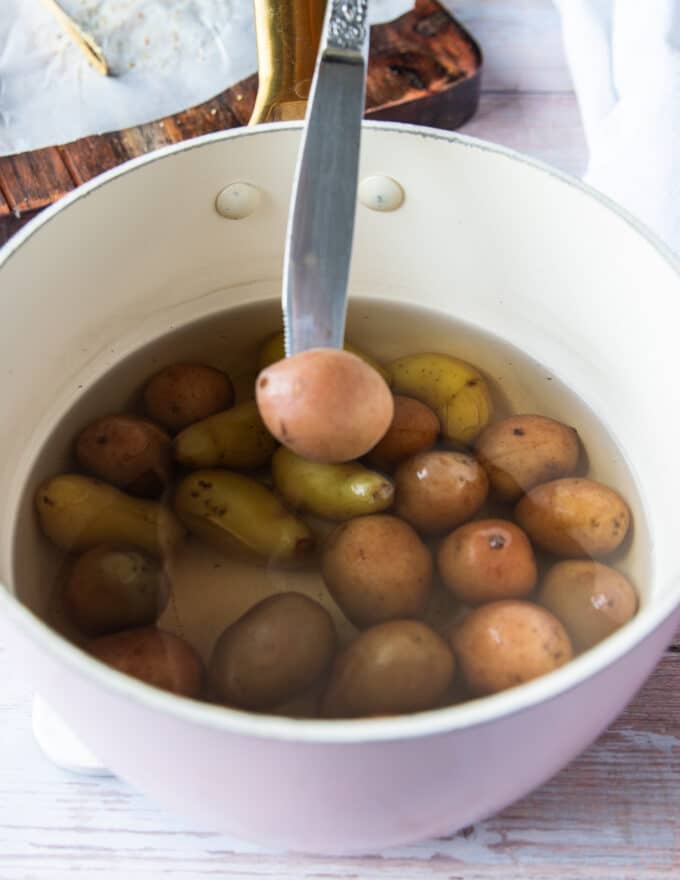 a knife poking through a potato showing how tender it is 