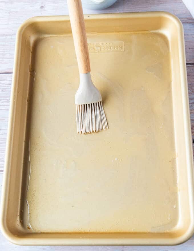Oil and butter brushed over a baking sheet