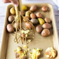 A masher used to smash the potatoes one at a time on the baking sheet