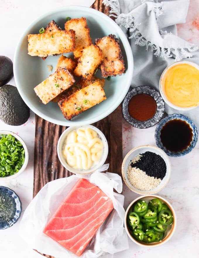 Ingredients to make spicy tuna crispy rice on a board with small bowls