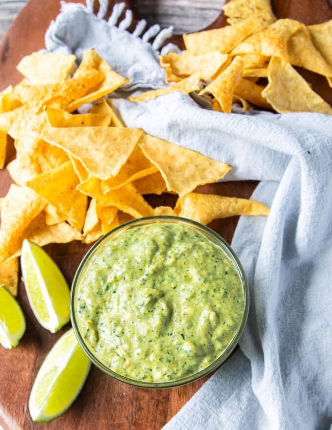 Lime wedges surrounding a bowl or poblano sauce so smooth and smoky ready to use
