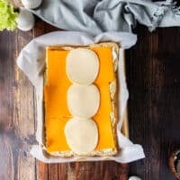 The cheese is spread over the bottom of the slider bread