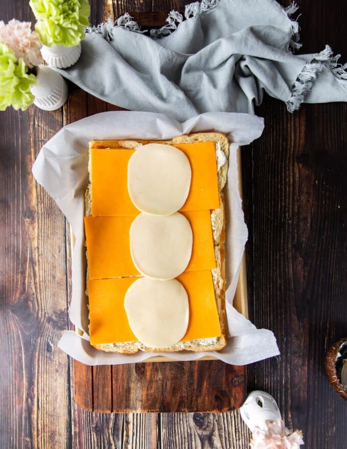 The cheese is spread over the bottom of the slider bread