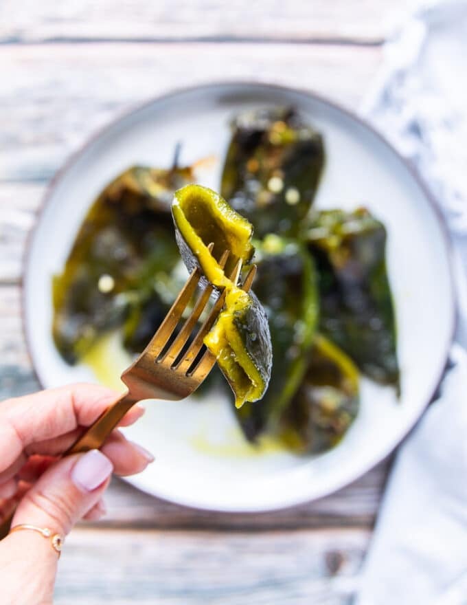 A fork holding a piece of roasted poblano peppers close up showing the soft texture
