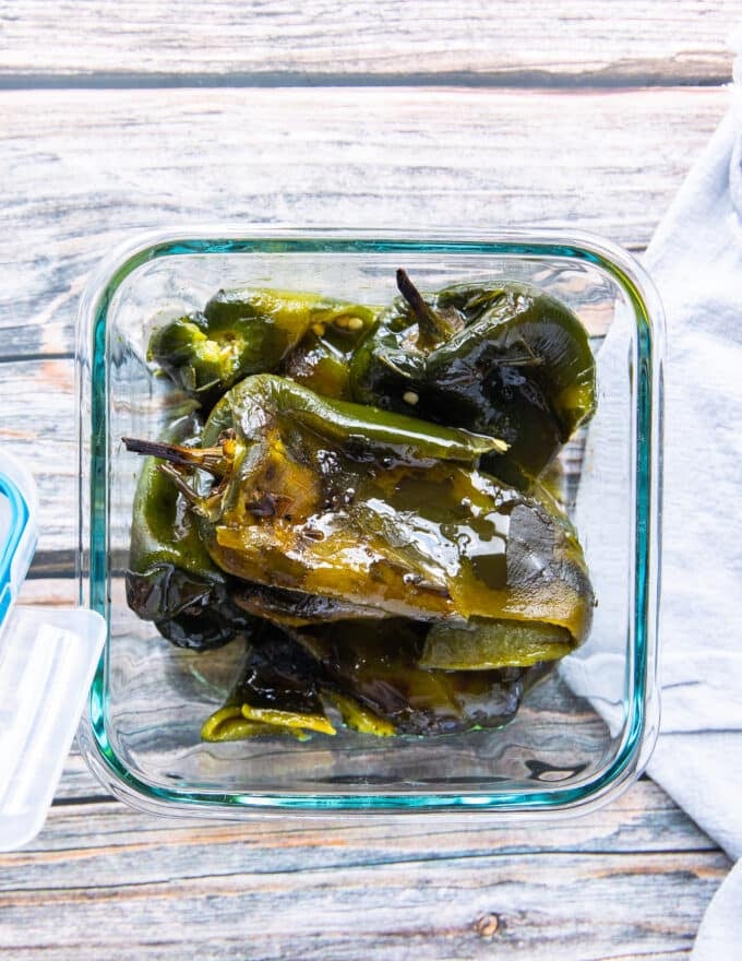 roasted poblano peppers in an airtight container stored for later in olive oil