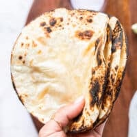 a hand holding charred tortillas close up